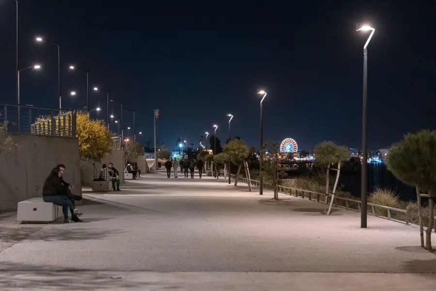 The Lac 0 promenade lit at night, people on the benches